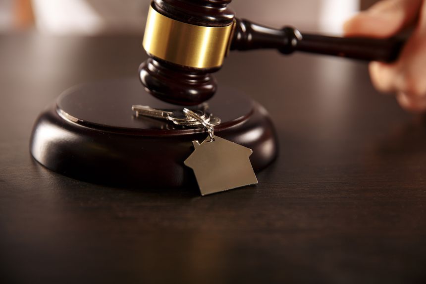 Wooden gavel with keys on the desk. Estate concept