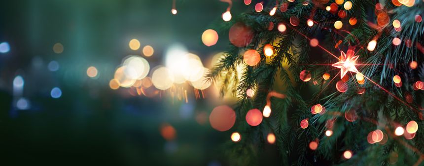 Christmas tree with bright star and illumination lights. Evening city with blurred background