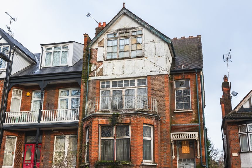 An abandoned terrace house, boarded up and neglected, around Hornsey in London