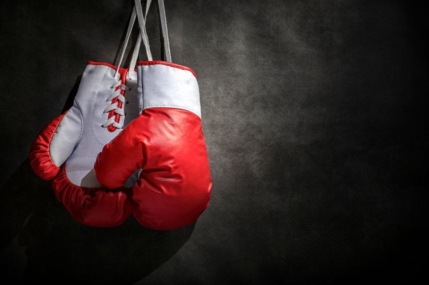Boxing gloves hanging on wall low key grunge gray background with copy space
