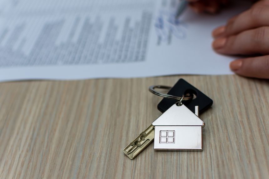 A person signs a contract for the purchase of a new apartment