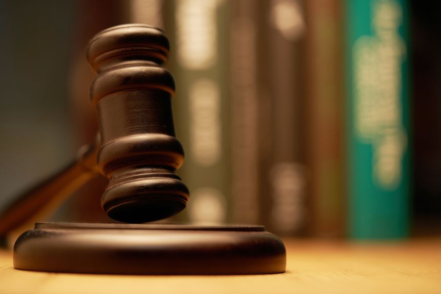 Gavel on wooden desk with books as background