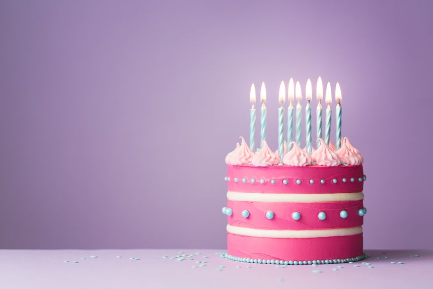 Pink birthday cake with nine candles
