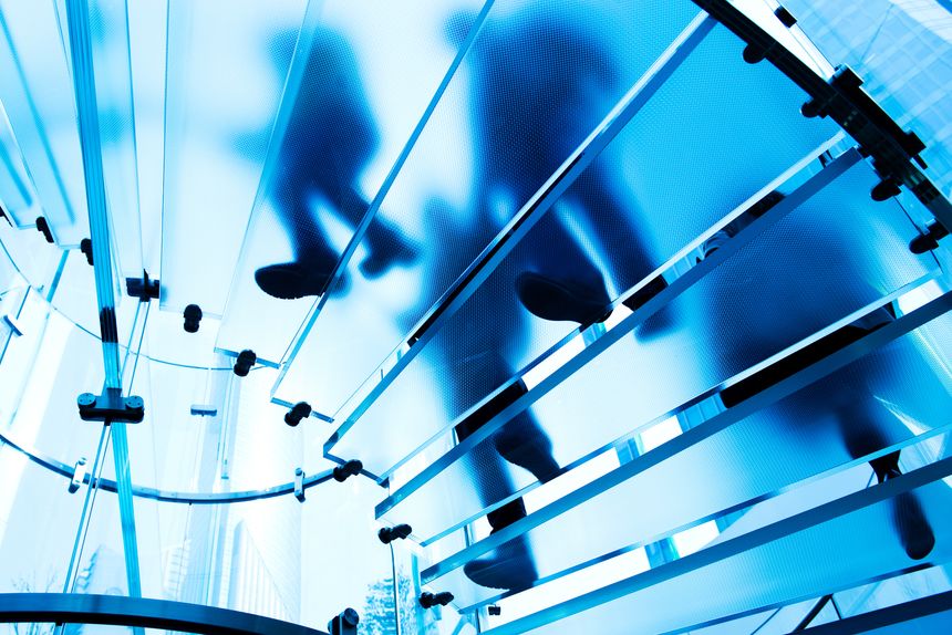 Silhouette people on glass staircase