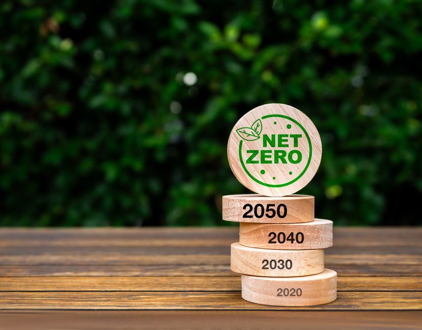 Net zero by 2050. Reduce CO2 emissions, carbon dioxide reduction, limit climate change, global warming concept. Net Zero icon on round wood blocks stack with 2010 to 2050 years on wood background.