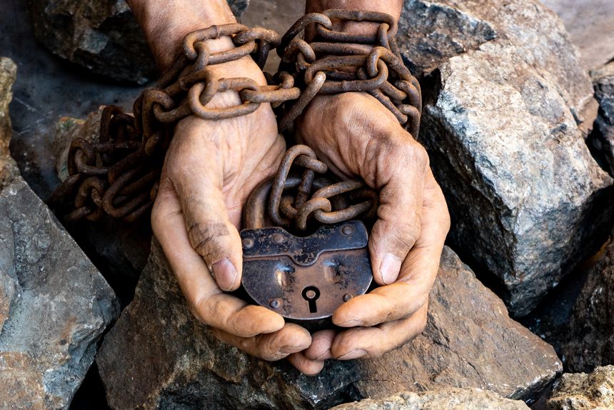 The hands of a slave in an attempt to free himself. Hands in chains