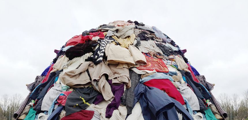 textile pollution, fast fashion industry waste, old clothing cloth fabric garment trash garbage pile stack heap background, concept of fast fashion industry tax and recycling