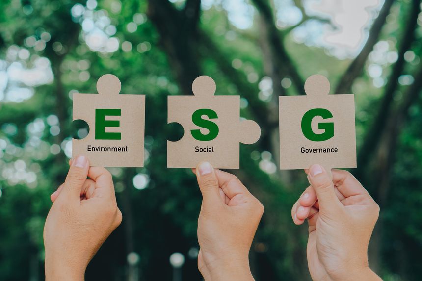 Hand holding Jigsaw with ESG icon concept.ESG icon for environmental, social, and governance in sustainable and ethical business on a green background.Teamwork,renewable,responsibility concept