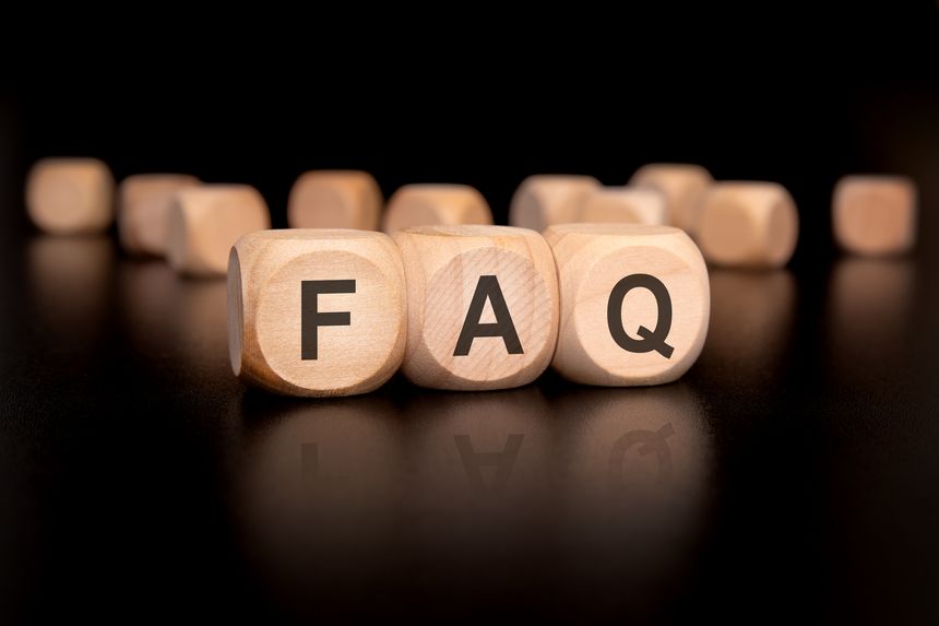 Wooden blocks are arranged to prominently display the letters FAQ, which represents frequently asked questions