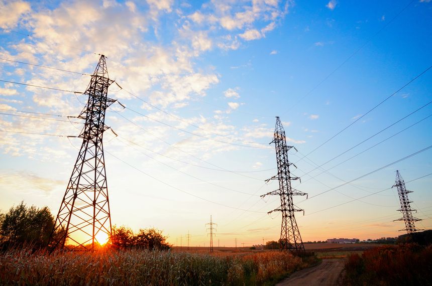 Transmission tower With Wires on Colorful Sky in Farm Field. Power tower on sunset with clouds. Electric tower. Electrical Transmission Line Tower. High voltage electricity tower sky sunset landscape.