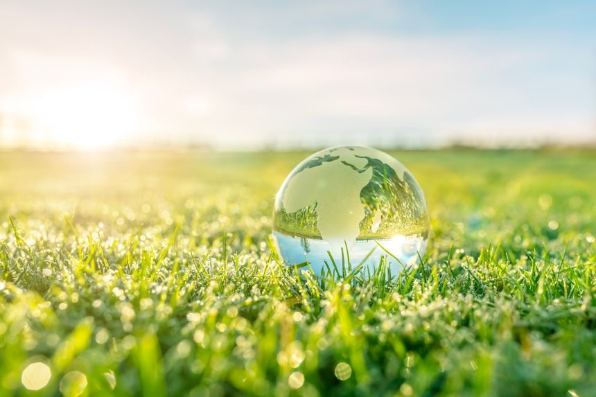 Glass globe in nature concept for environment and conservation, renewable energy and sustainable development