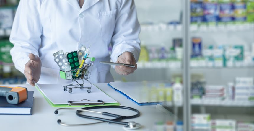The concept of medication availability and health care. A pharmacist shows a shopping cart with medicines.