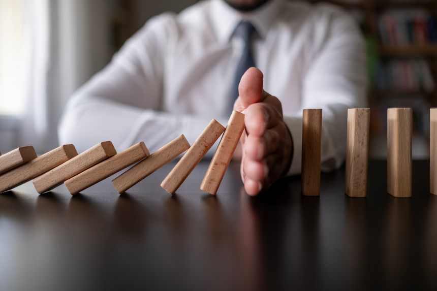 Concept of Risk Assessment, Risk Management, Risk, Business, Economic, Financial Crisis. Business man stop wooden block domino effect to safe, protect family, home from economic, Insurance