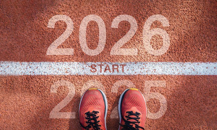 New year 2026 concept, beginning of success. Text 2026 written on asphalt road and male runner preparing for the new year. Concept of challenge or career path and change.