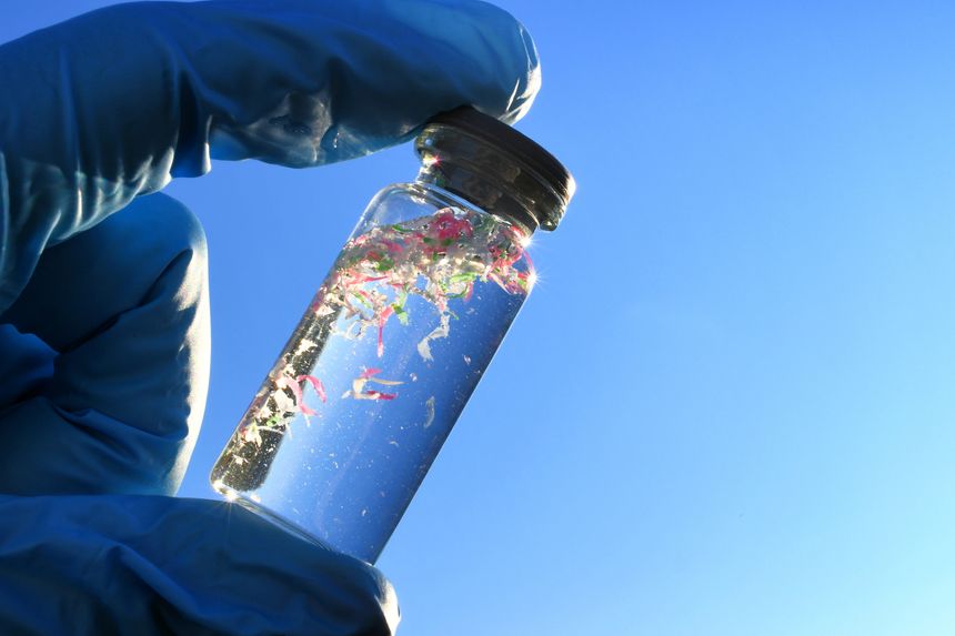 A glass vial containing water and micro plastic pieces of pollution