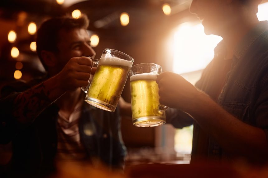 Close up of men toasting while celebrating in a bar.