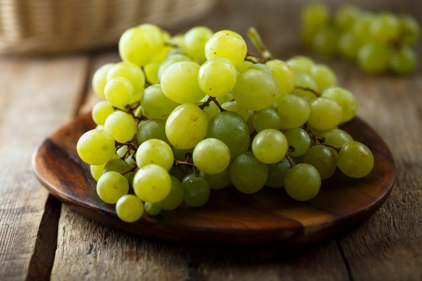 Ripe white grape on wooden desk