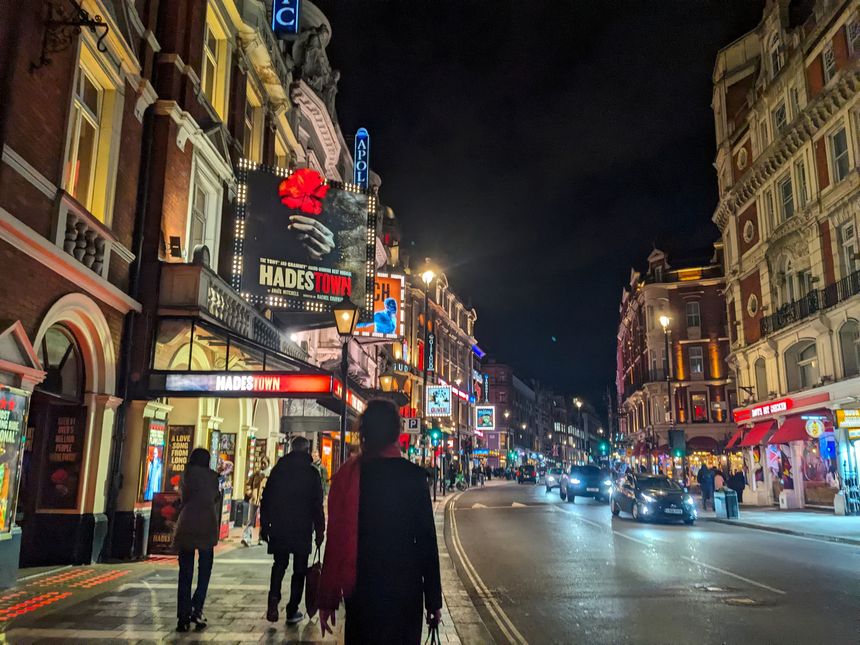 London, UK - November 18 2025: A bustling night scene on Shaftesbury Avenue in the West End, with pedestrians strolling past the brightly illuminated Lyric Theatre showing the musical Hadestown
