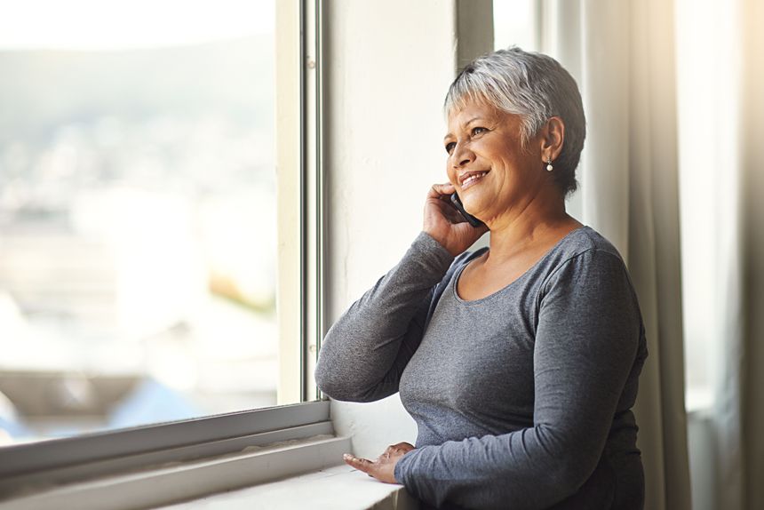 Shot of a mature woman using her cellphone at home