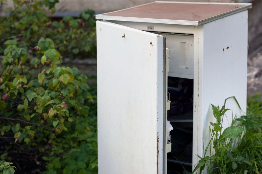 old discarded fridge abandoned outdoor and used like a storage