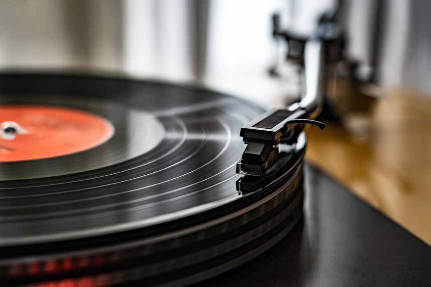 A close-up of a spinning vinyl record on a turntable, capturing the motion of grooves and the stylus. Classic analog music setup evokes nostalgia, creativity, and warm sound.