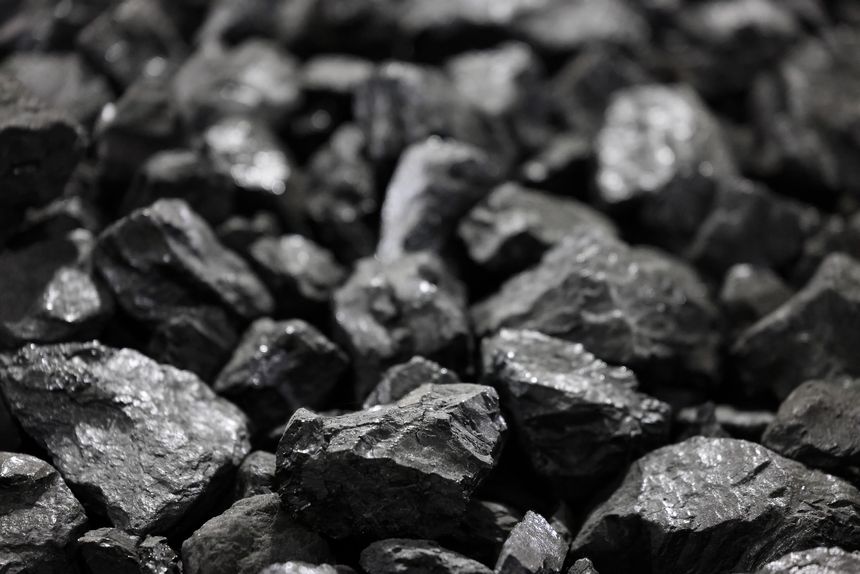 Coal background concept. Low angle view, focus in foreground. Fossil fuel, carbon dioxide emissions, climate change, environmental issues. Energy sources for electricity generation, industrial steel production
