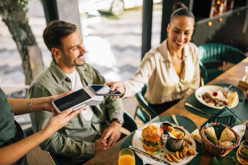People paying with contactless credit card in a restaurant.