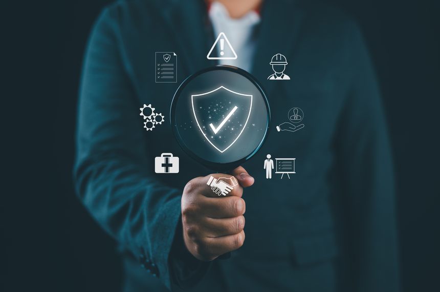 Work Safety and Compliance Concept. Businessman holding magnifying glass with icons work safety, compliance, risk management, and operational efficiency, emphasizing importance of safety standards.