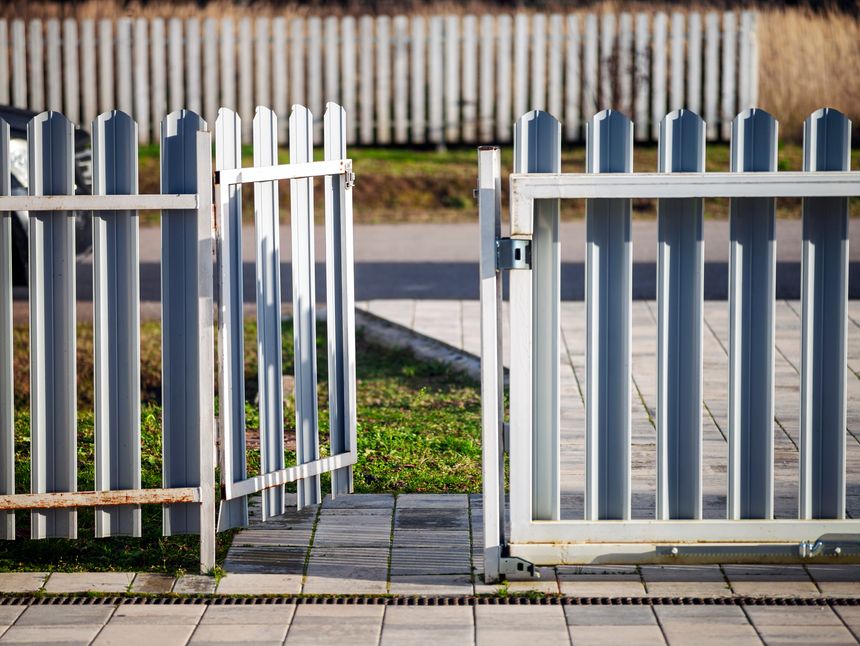 a metal fence and entrance door left open, sunny daylight shot