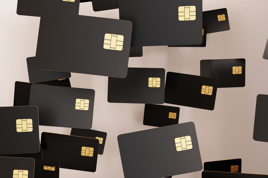 Multiple black credit cards are shown falling in a 3D environment. Each card has a gold chip. The background is light and simple, providing focus on the cards.