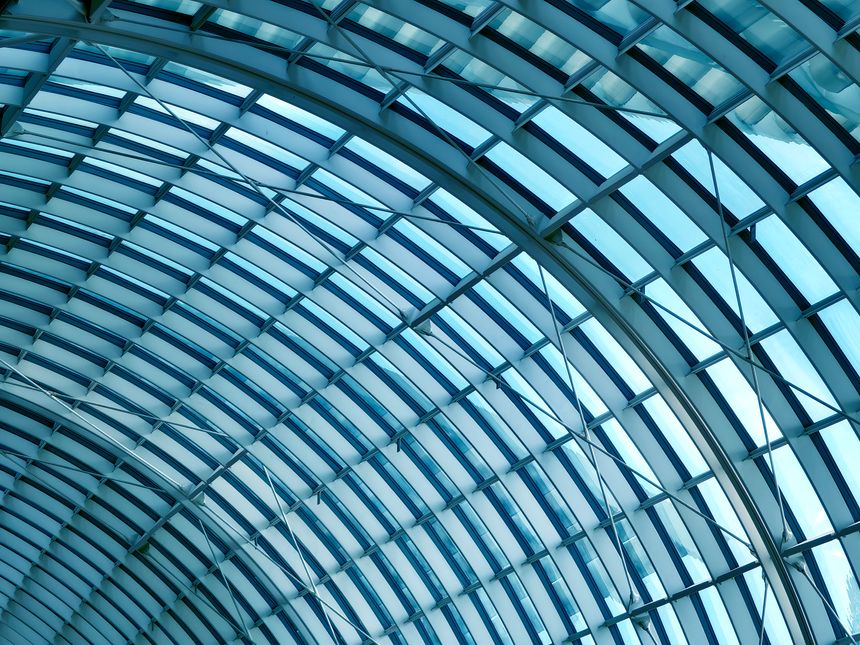 Glass canopy showcasing repeating geometric frames and day light.