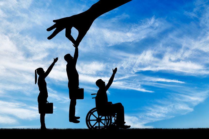 Employer's hand chooses a healthy worker from a crowd of people and not an invalid in a wheelchair. The Concept of Discrimination and Inequality in the Employment of People with Disabilities