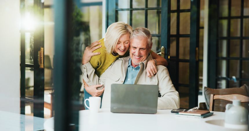 Happy, hug and senior couple with laptop, home or excited for pension fund, flare and financial plan. Online, old woman and embrace with elderly man for success, retirement and reading good news