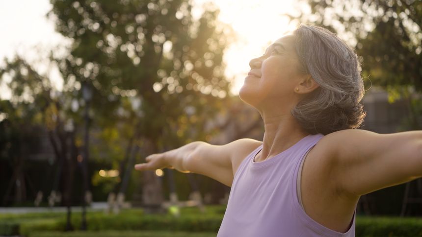 Asia adult aged people middle age mindful happy old woman open arm yoga deep calm stress relief outdoor nature public park sun light self love relax elder aging life asian female mental health care.