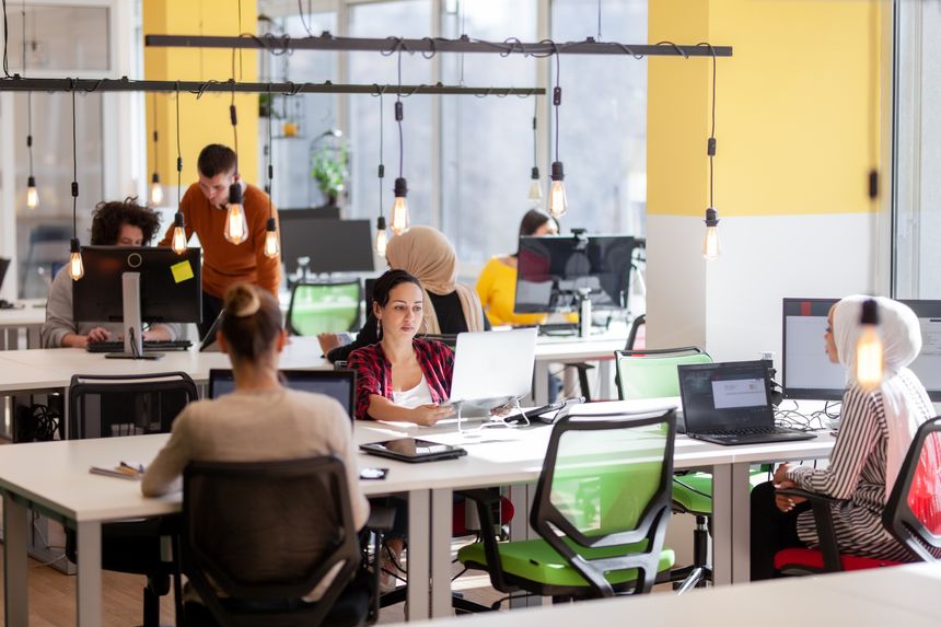 Creative team of young individuals working on desktop computers in a modern office space.