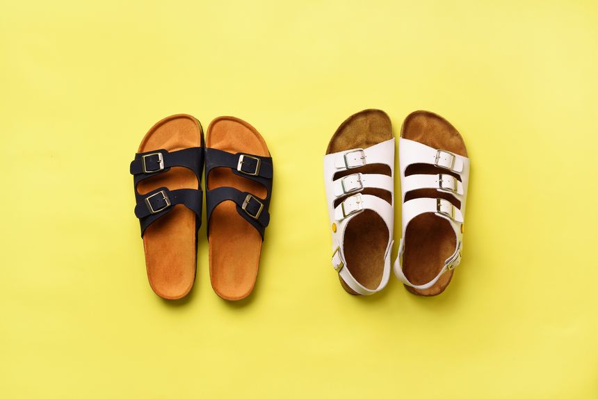 Summer female shoes - sandals (birkenstock) and slippers on yellow background with copy space. Top view. Minimal flat lay. Selection concept.