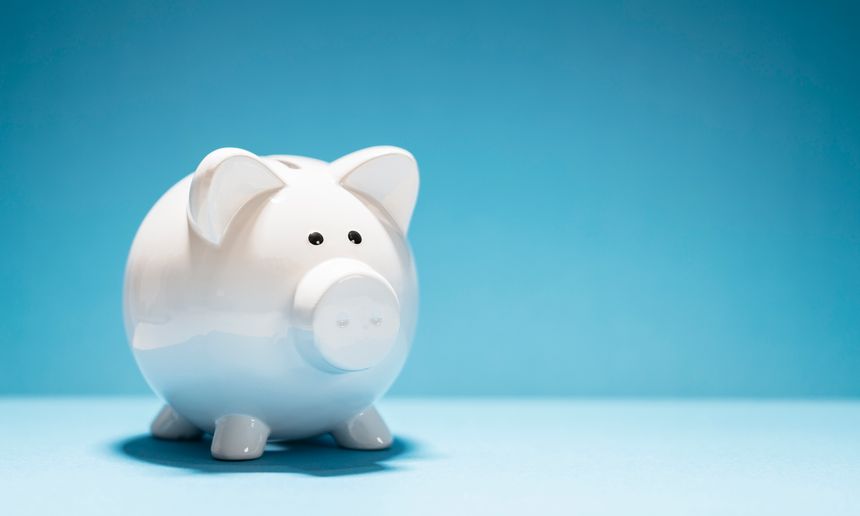 White piggy bank on blue background with copy space