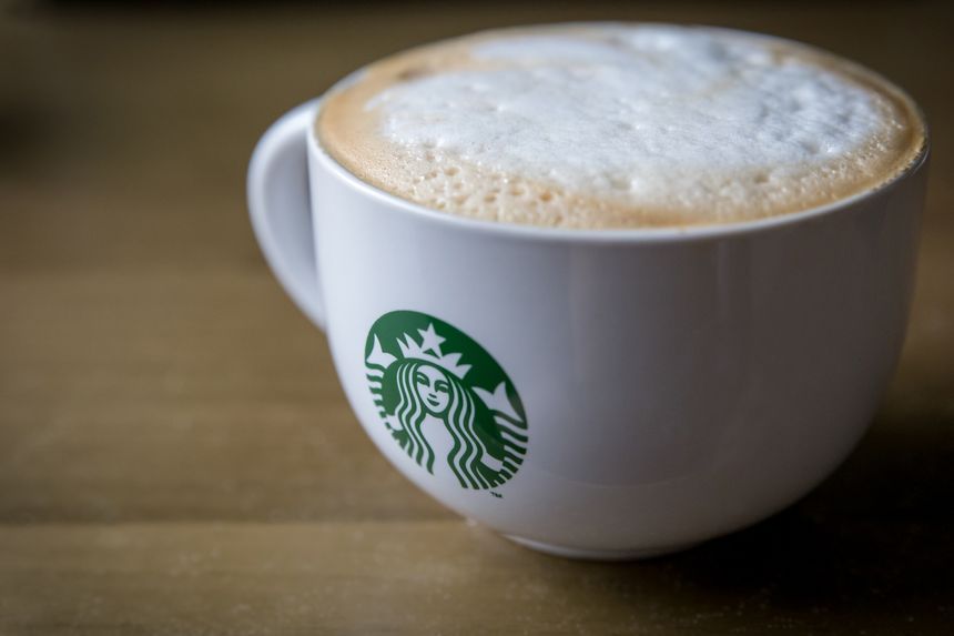 London, England - October 2, 2013: Close up of a Starbucks branded Cappucino Mug on a brown table.