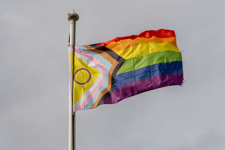 Newcastle upon Tyne, United Kingdom – March 19, 2023: Intersex-Inclusive Pride Progress flag on a flag pole with a grey cloud background.