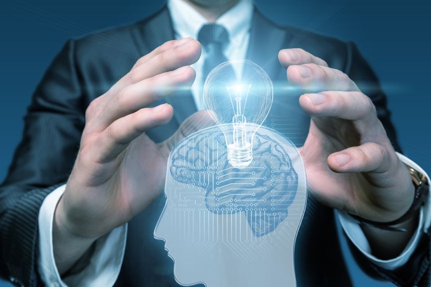 Innovating ideas with technology in business mindset. Hands create a vision of a human brain illuminated by a light bulb showcasing innovation.