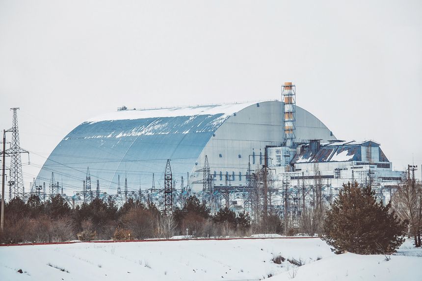 An iconic view of the Chernobyl New Safe Confinement shielding the destroyed Fourth Unit. A symbol of the catastrophic nuclear accident, radiation legacy, and the ongoing efforts to contain fallout.