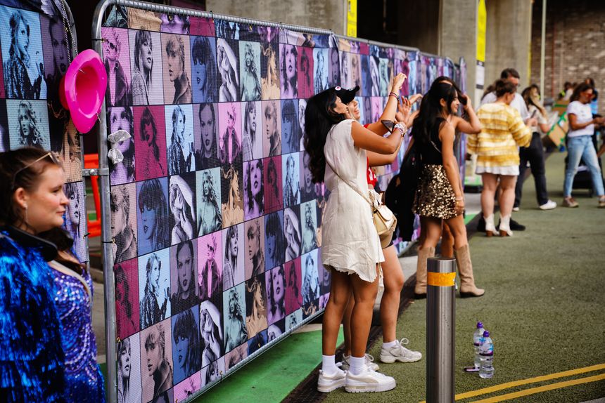 London HA9, Brent, United Kingdom – On August 17, 2024 — fans dressed in pink dresses reminiscent of Taylor Swift's iconic styles, awaiting the concert at Wembley Park - Wembley Stadium in the northwest of Central London. The Taylor Swift merchandise, store, the Eras Tour shop, retail place, including bags and shirts, reflecting the commercial aspect of this large-scale event.Concert crowd, Summer concert, Live music, Music festival. Merchandise, Fan culture, London event.