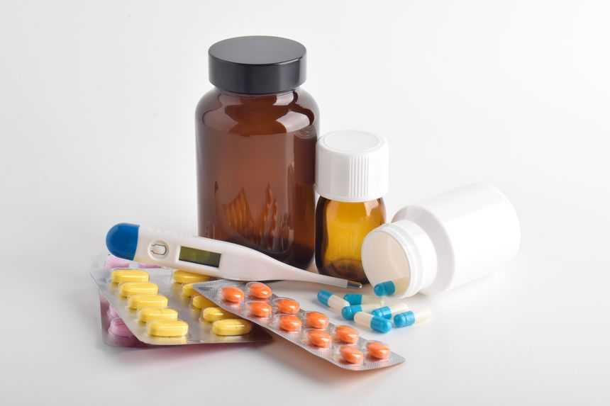 Pills, thermometers, and medicine bottles on a white background. Concept of healthcare products and medical treatment supplies.