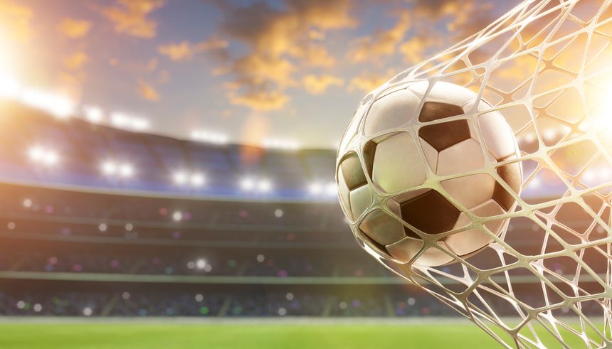 Soccer ball hitting the net inside a stadium during a football match at sunset. 3d rendering