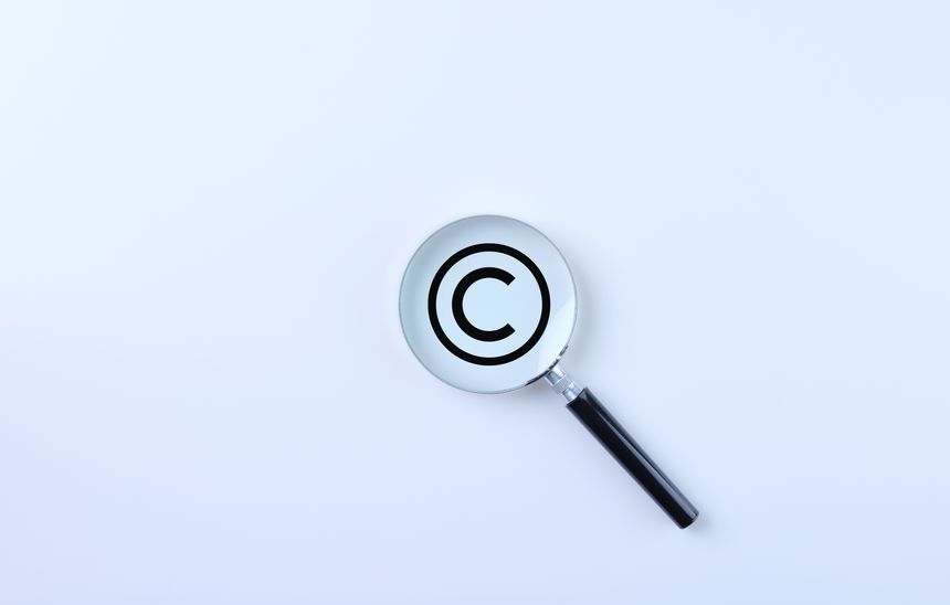 Copyright protection and patenting concept. Magnifying glass magnifies the copyright symbol on a white background. copyright symbol, Intellectual property, Patent protection, Register trademark brand,