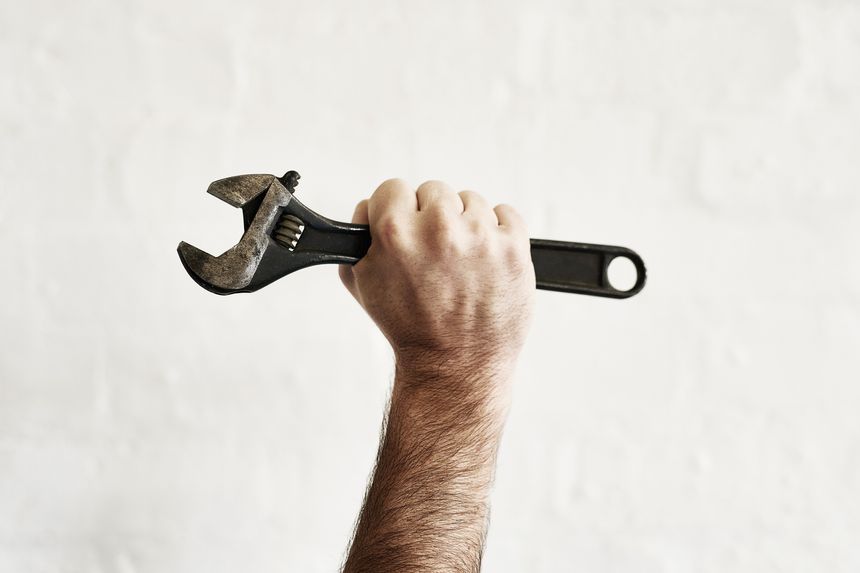 Shot of an unrecognizable handyman holding up a monkey wrench