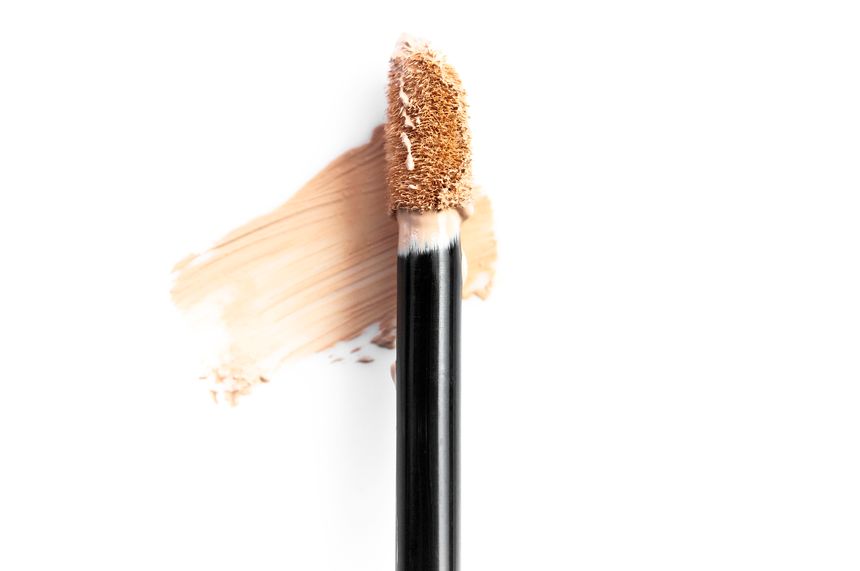 Concealer brush for face makeup isolated on white background. Liquid foundation, decorative cosmetics. Foundation face make-up samples, texture of face concealer. Make up smears. Cosmetic background.
