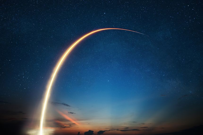 Stunning long exposure of a rocket launch streak arching across a starry night sky during twilight. Spaceship rocket lift off to the space. Shuttle takeoff, creative