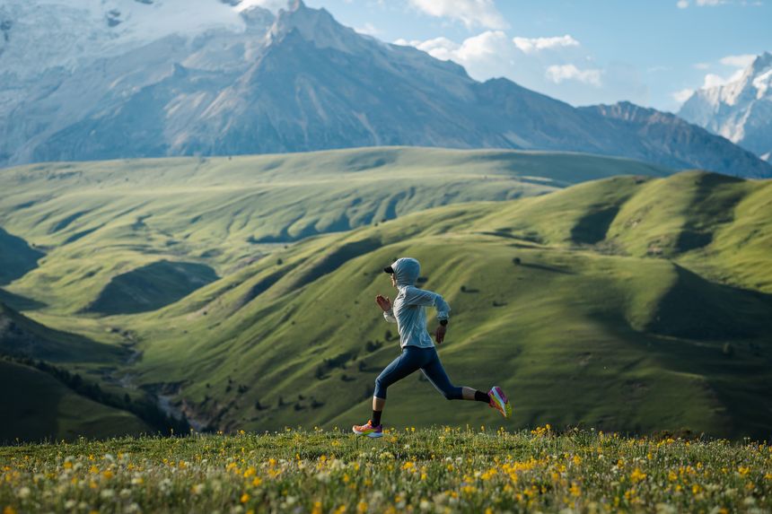 Trail runner running  on the high altitude grassland mountain top trail