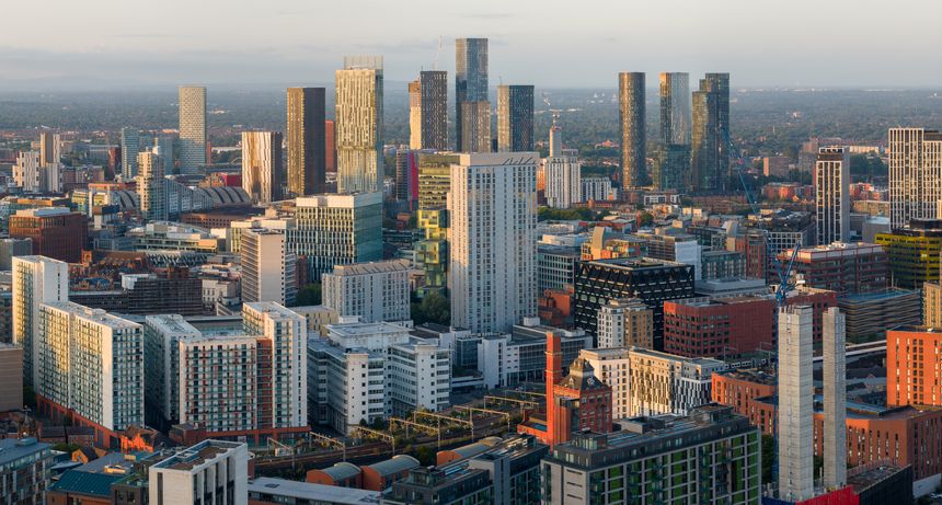 Aerial panoramic perspective of Manchester Skyline touched by the morning sunlight featuring high-rise apartment and office building
